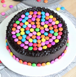 Choco Gems Cake Delight featuring a rich chocolate cake topped with vibrant, colorful choco gems, ideal for adding a sweet touch to any celebration.