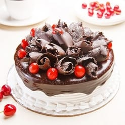 Chocolate Black Forest Cake with rich chocolate layers, cherries, and whipped cream, elegantly decorated for a delicious and festive dessert.