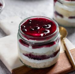 Duo of berry cake jars featuring layers of mixed berries and creamy frosting, perfect for dessert lovers and gifting.