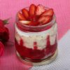 Berry Bliss Jar Cake Delight featuring layers of moist cake with mixed berries and creamy frosting, presented in individual jars for a delightful treat.