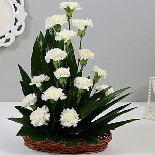 Cane Basket Arrangement White Carnations featuring a stylish cane basket filled with fresh white carnations, ideal for gifting or decoration.