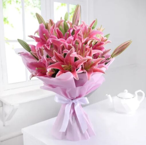 Stunning bouquet of elegant pink lilies wrapped in tissue, perfect for gifting and adding a touch of beauty to any occasion.