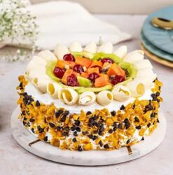 Fruit-filled cake topped with a variety of fresh fruits, showcasing a moist and flavorful dessert ideal for special occasions.