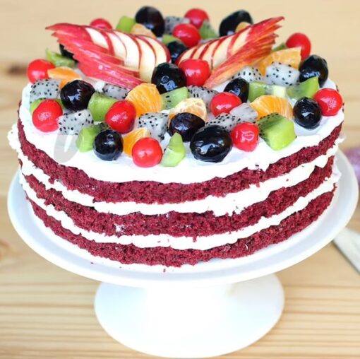 Fruit Filled Red Velvet Cake featuring layers of rich red velvet cake adorned with fresh, colorful fruit, ideal for a festive dessert.