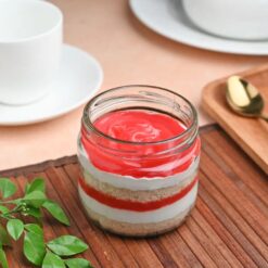 Strawberry Bliss Solo Jar Cake featuring layers of moist cake and fresh strawberries with creamy frosting, presented in a single jar for a delicious treat.