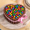 Heart-shaped KitKat Gems Cake decorated with chocolate bars and colorful candy gems, ideal for celebrations and special occasions.