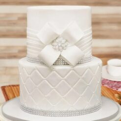 Crystal White Tier Cake with elegant white frosting and decorative accents.