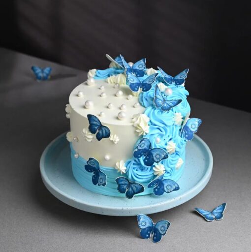 Luxurious butterfly-themed cake with intricate fondant details and elegant decorations.