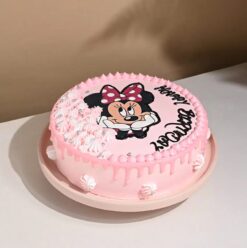 Charming Pretty Minnie Mouse Cake with pink and white designs, polka dots, a fondant bow, and delightful details.