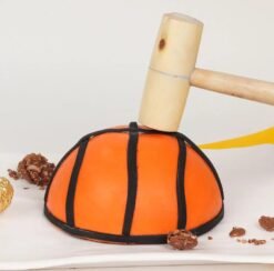 Ferrero Basketball Pinata Cake shaped like a basketball, featuring chocolate layers, Ferrero Rocher treats, and a sporty design.