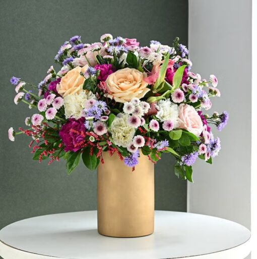 Golden Vase Blooming Symphony – A vibrant arrangement of colorful blooms in a luxurious golden vase, ideal for adding elegance to any occasion.