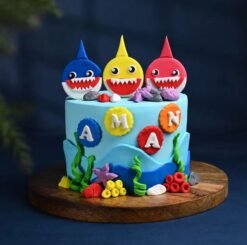 Baby Shark Cake with colorful ocean-themed decorations, featuring Baby Shark family toppers, waves, and edible sea creatures, perfect for kids' parties.