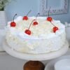 White Forest Delight Cake with soft vanilla sponge, layers of whipped cream, white chocolate shavings, and cherry toppings.