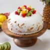 Delicious Fruit Celebration Cake — vibrant cake topped with assorted fresh fruits and whipped cream, perfect for festive occasions.