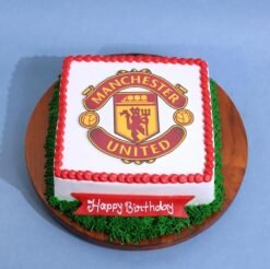 Manchester United Cake — red and black cake decorated with club crest, football elements, and Man Utd-themed toppers.
