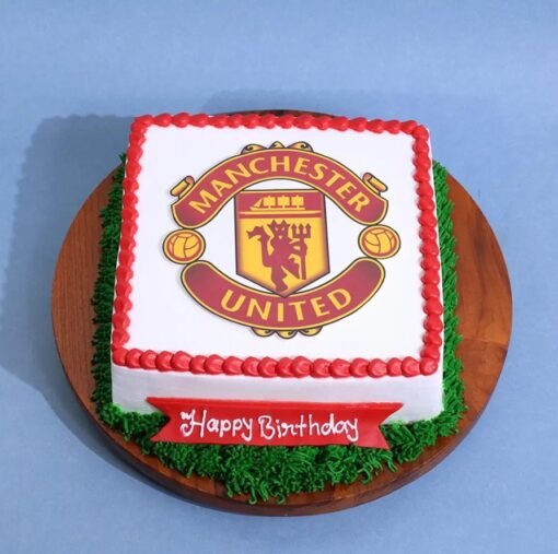 Manchester United Cake — red and black cake decorated with club crest, football elements, and Man Utd-themed toppers.