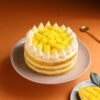 Mango Cream Dream Cake topped with mango glaze, cream swirls, and fresh mango chunks.