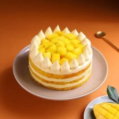 Mango Cream Dream Cake topped with mango glaze, cream swirls, and fresh mango chunks.