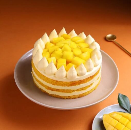 Mango Cream Dream Cake topped with mango glaze, cream swirls, and fresh mango chunks.