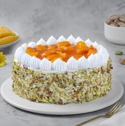 Mango Pistachio Cream Cake topped with mango slices and crushed pistachios.