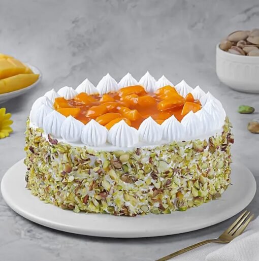 Mango Pistachio Cream Cake topped with mango slices and crushed pistachios.