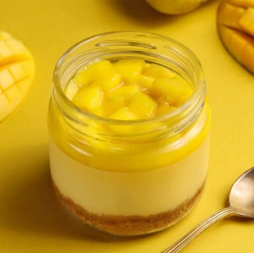 Silky Mango Jar Cheesecake with creamy mango layers and biscuit base in a clear jar.